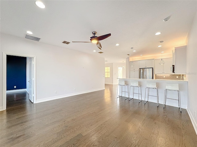 unfurnished living room featuring dark hardwood / wood-style flooring and ceiling fan