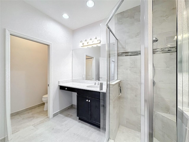 bathroom with an enclosed shower, vanity, and toilet