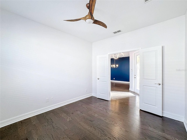 unfurnished room featuring ceiling fan with notable chandelier and dark hardwood / wood-style flooring