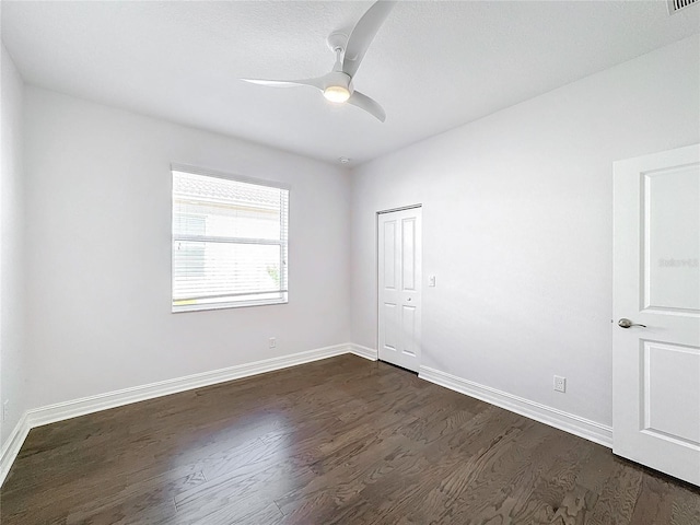 spare room featuring ceiling fan and dark wood-type flooring