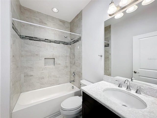 full bathroom featuring vanity, tiled shower / bath combo, and toilet