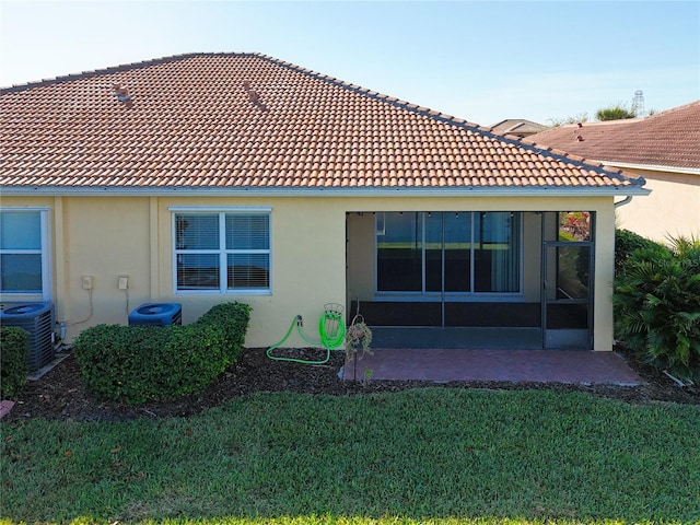 back of house with a yard, a patio, central AC unit, and a sunroom