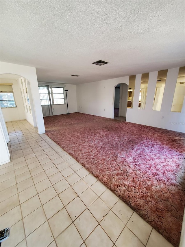 empty room featuring light tile patterned floors and a textured ceiling