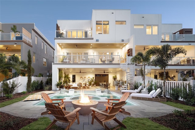 rear view of house featuring a patio, stucco siding, a ceiling fan, fence, and a balcony