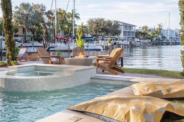 view of pool with an in ground hot tub, a water view, and an outdoor fire pit