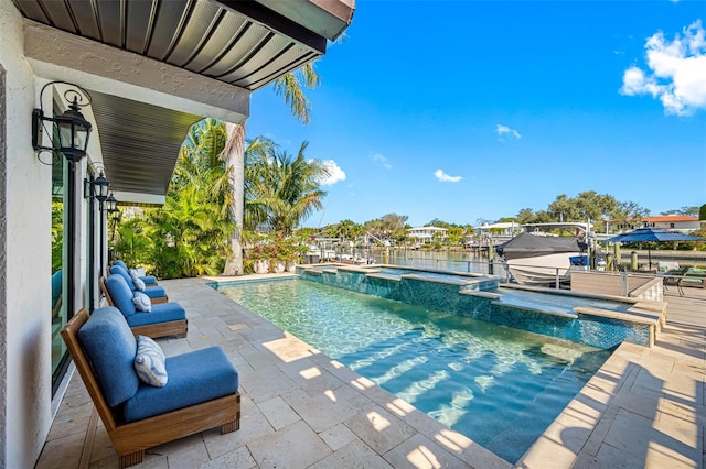 view of pool with a patio area and a water view