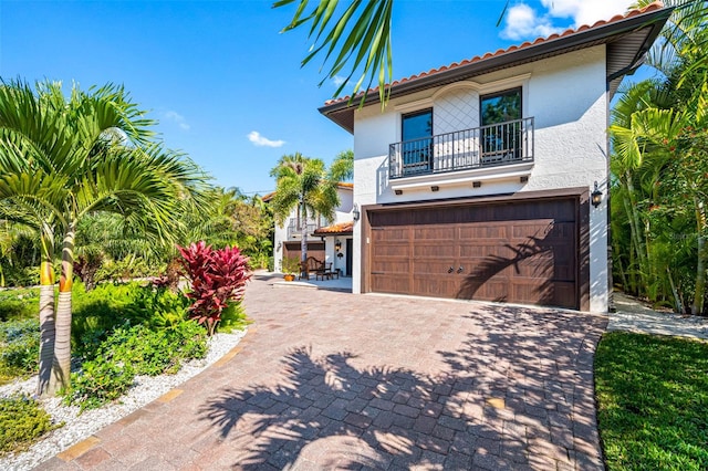 mediterranean / spanish-style home with a balcony and a garage