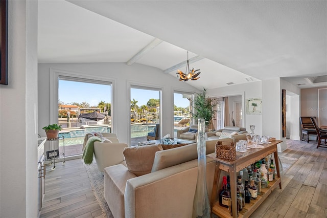 living room featuring vaulted ceiling with beams, light wood-type flooring, and an inviting chandelier