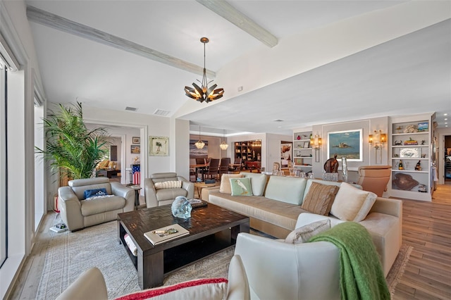 living room featuring beamed ceiling, a notable chandelier, and light hardwood / wood-style flooring