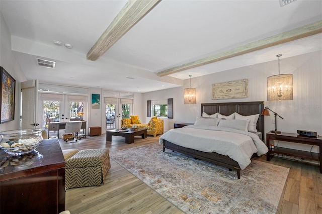 bedroom with french doors, beamed ceiling, a chandelier, and hardwood / wood-style flooring