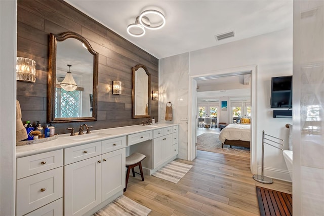 bathroom featuring vanity, hardwood / wood-style flooring, and wooden walls