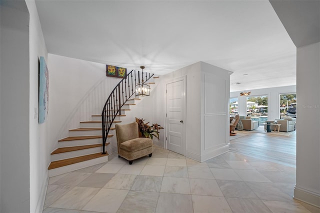 stairway featuring a chandelier