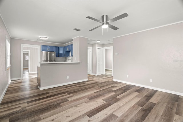 unfurnished living room featuring dark hardwood / wood-style floors, ceiling fan, and ornamental molding