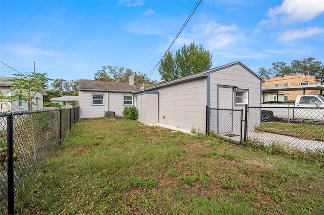 back of house featuring a yard and central AC