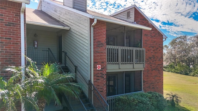 view of side of home featuring a yard and a sunroom