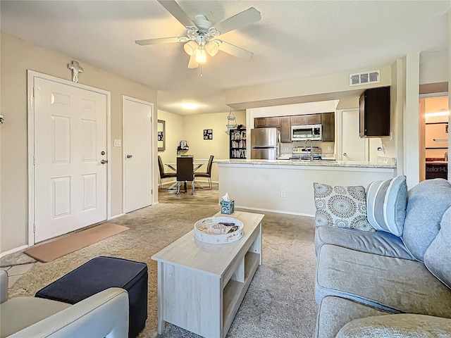 living room featuring light carpet and ceiling fan