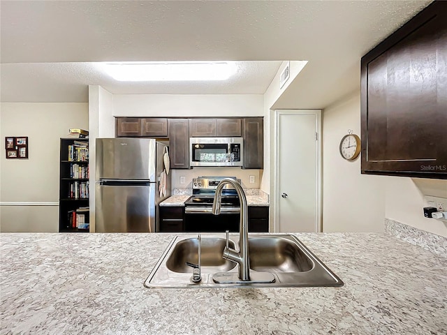 kitchen featuring sink, dark brown cabinets, and appliances with stainless steel finishes