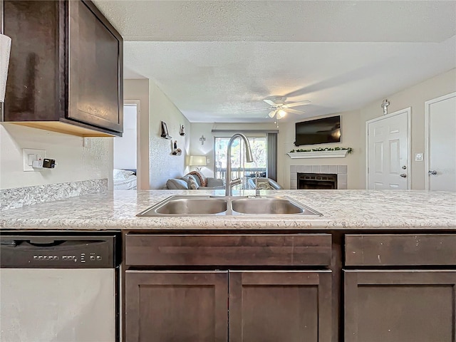 kitchen featuring sink, stainless steel dishwasher, ceiling fan, dark brown cabinets, and a textured ceiling