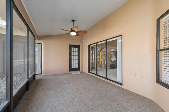 unfurnished sunroom featuring ceiling fan