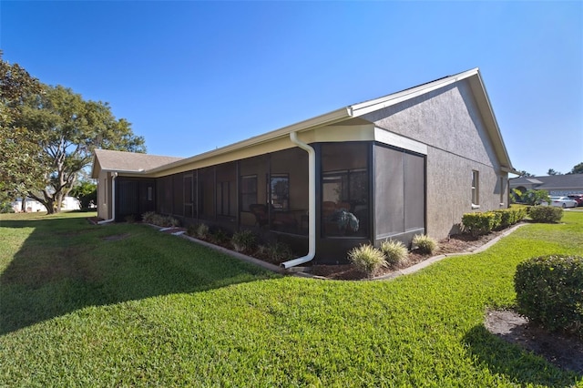 view of side of property with a lawn and a sunroom