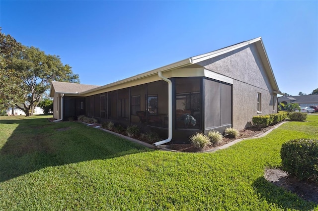 view of home's exterior featuring a sunroom and a lawn