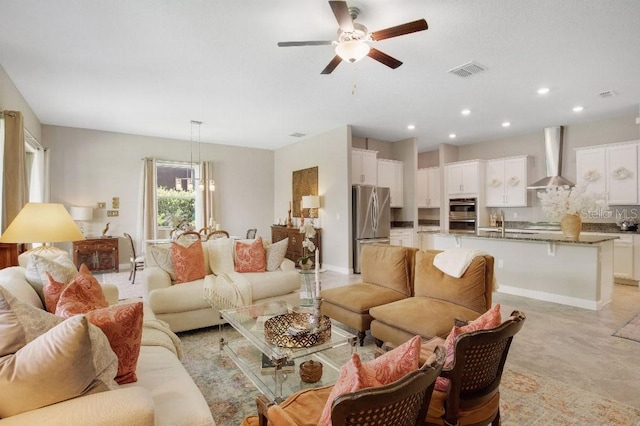 living room with ceiling fan with notable chandelier