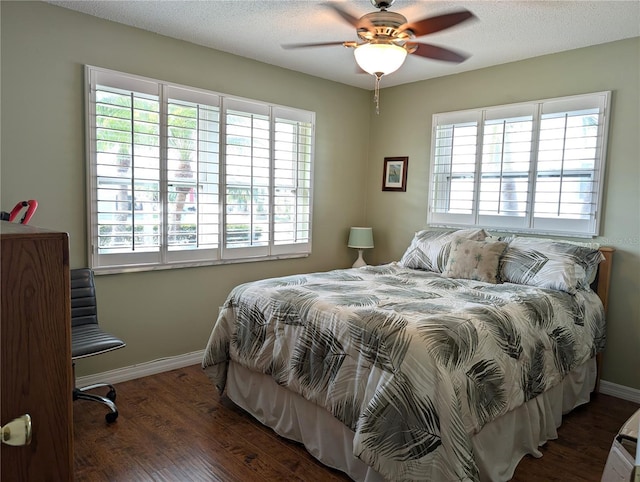 bedroom featuring multiple windows, ceiling fan, a textured ceiling, and dark hardwood / wood-style flooring