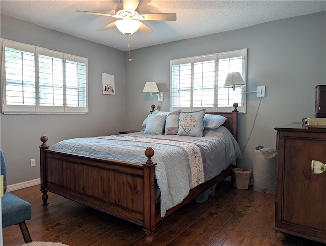 bedroom featuring multiple windows, a textured ceiling, dark hardwood / wood-style floors, and ceiling fan