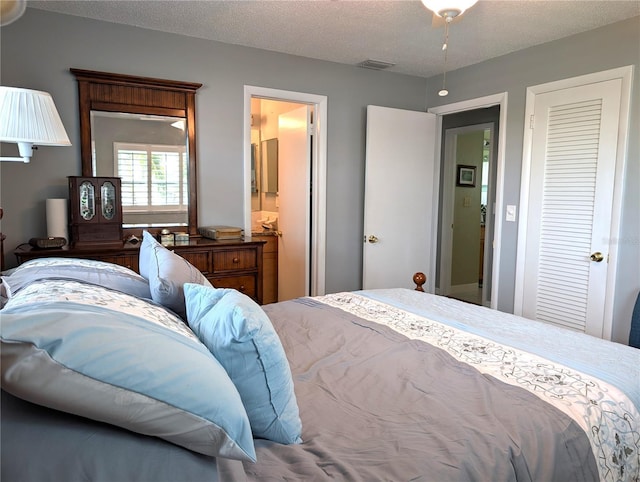 bedroom with connected bathroom and a textured ceiling