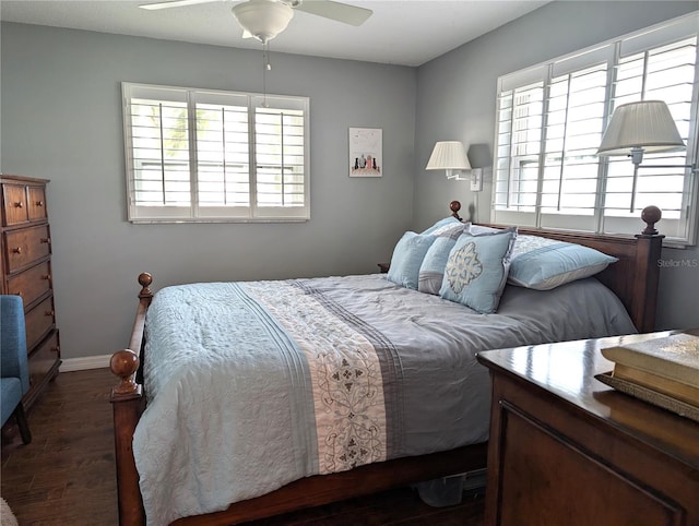 bedroom featuring ceiling fan, dark hardwood / wood-style flooring, and multiple windows