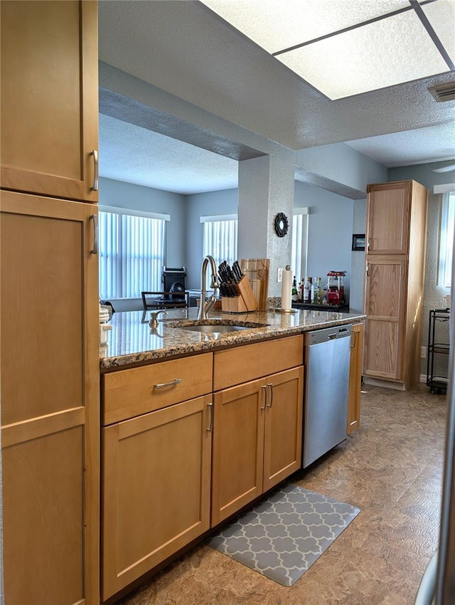 kitchen featuring dark stone countertops, sink, a textured ceiling, and dishwasher