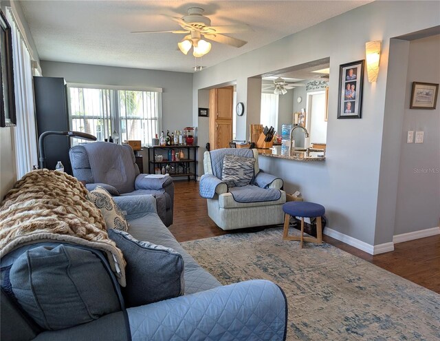 living room featuring sink, hardwood / wood-style flooring, a textured ceiling, and ceiling fan