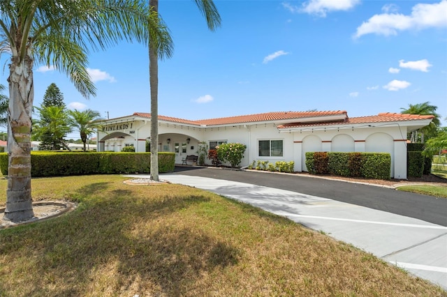 mediterranean / spanish home featuring a front lawn