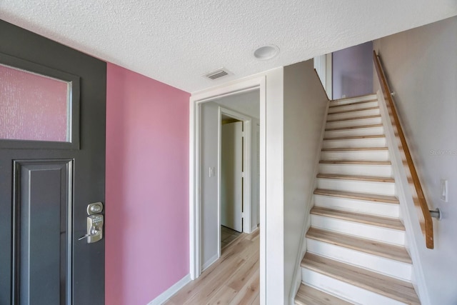 interior space with a textured ceiling and light wood-type flooring