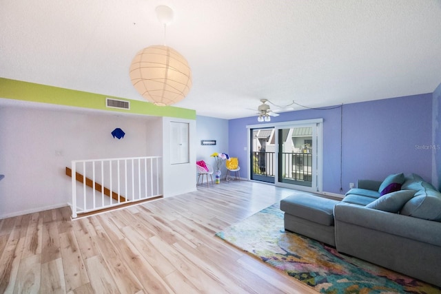 living room featuring ceiling fan and light wood-type flooring