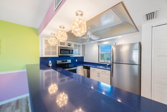 kitchen with sink, white cabinetry, stainless steel appliances, and light hardwood / wood-style flooring