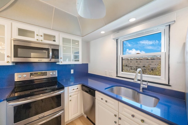 kitchen featuring decorative backsplash, stainless steel appliances, white cabinetry, and sink