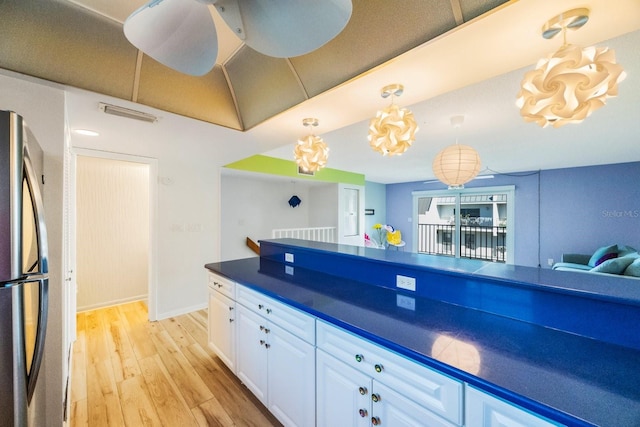 kitchen featuring stainless steel refrigerator, white cabinetry, ceiling fan, decorative light fixtures, and light wood-type flooring