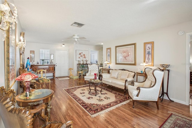 living room with wood-type flooring, a textured ceiling, and ceiling fan