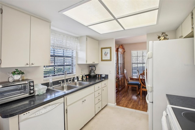 kitchen with sink, a healthy amount of sunlight, white appliances, and light hardwood / wood-style flooring