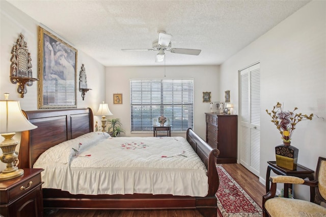 bedroom featuring ceiling fan, dark hardwood / wood-style flooring, a textured ceiling, and a closet