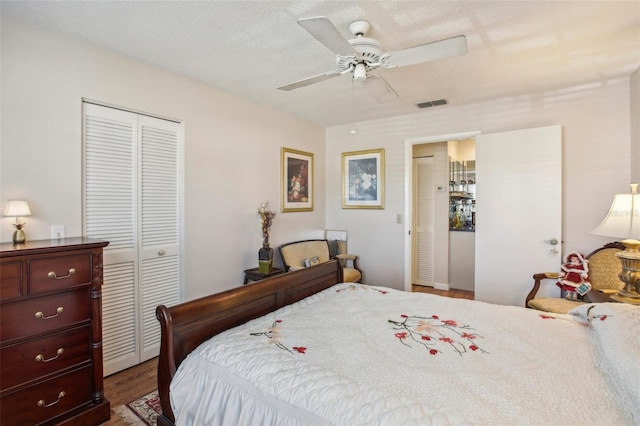 bedroom featuring a textured ceiling, ceiling fan, and dark wood-type flooring