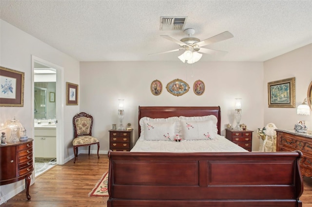 bedroom with connected bathroom, ceiling fan, a textured ceiling, and hardwood / wood-style flooring