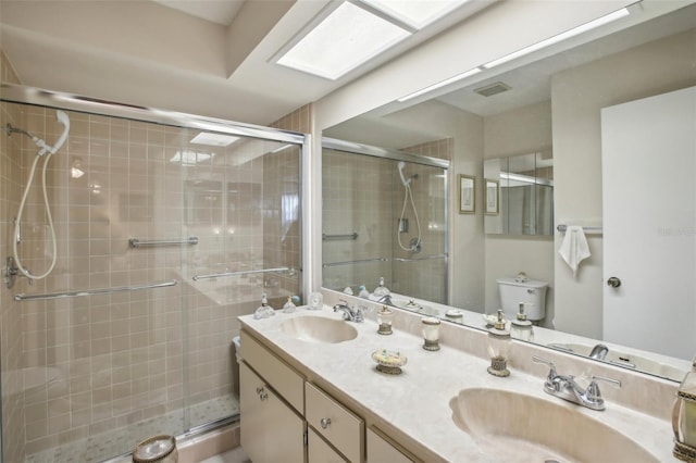 bathroom with vanity, toilet, and a shower with shower door