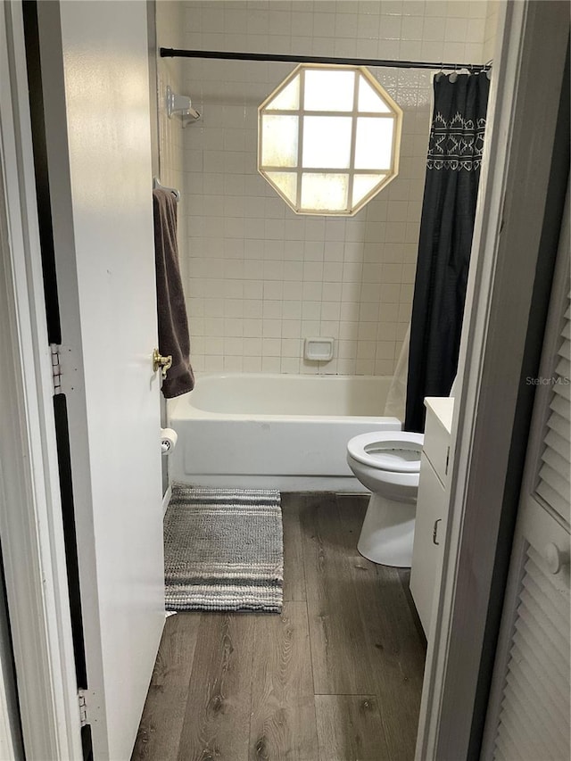 full bathroom with wood-type flooring, vanity, toilet, and shower / bathtub combination with curtain