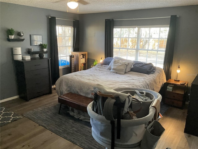 bedroom featuring ceiling fan, a textured ceiling, and light wood-type flooring