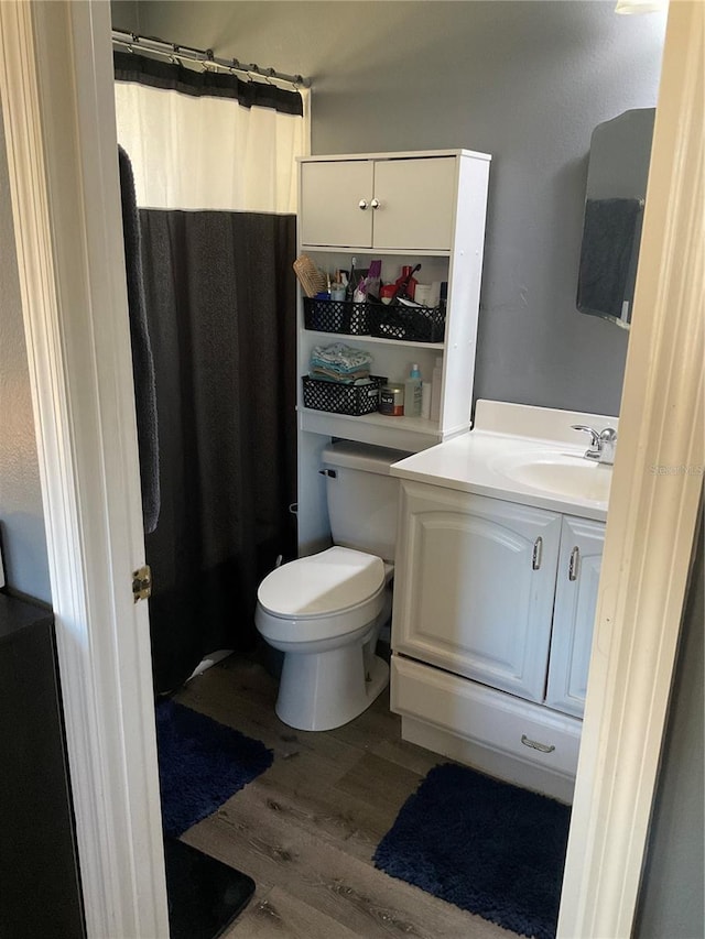 bathroom featuring a shower with curtain, vanity, hardwood / wood-style flooring, and toilet