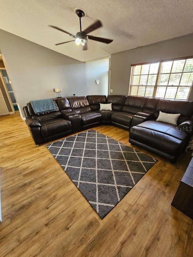 living room with a wealth of natural light, wood finished floors, and a ceiling fan