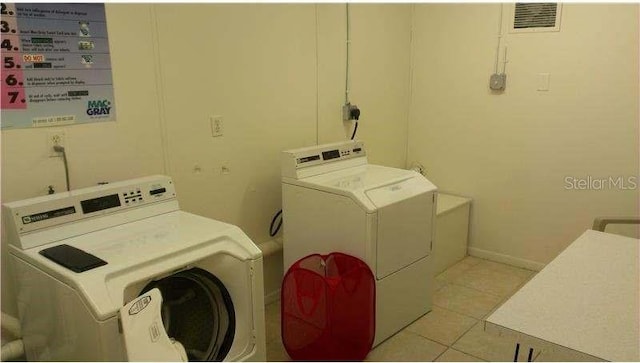 washroom with washer and clothes dryer and light tile patterned floors