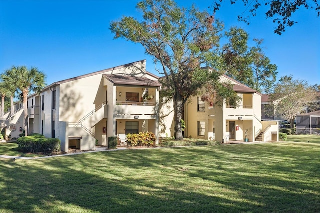 rear view of property with a balcony and a lawn